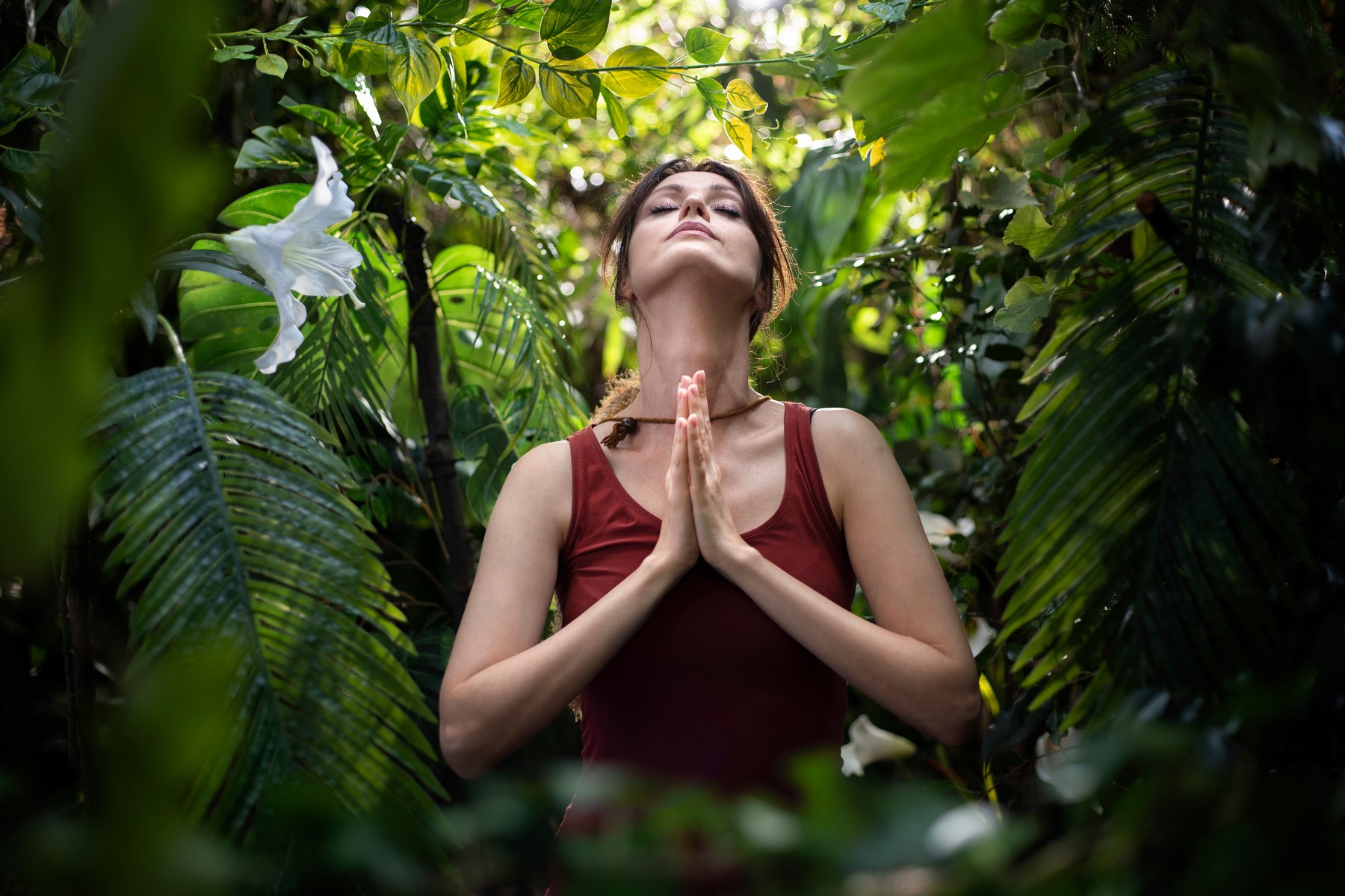 Woman practicing breathing yoga pranayama in rainforest