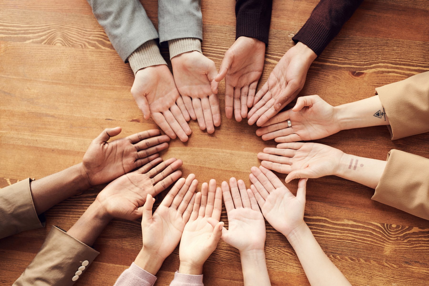 Palms of diverse group of people in a circle